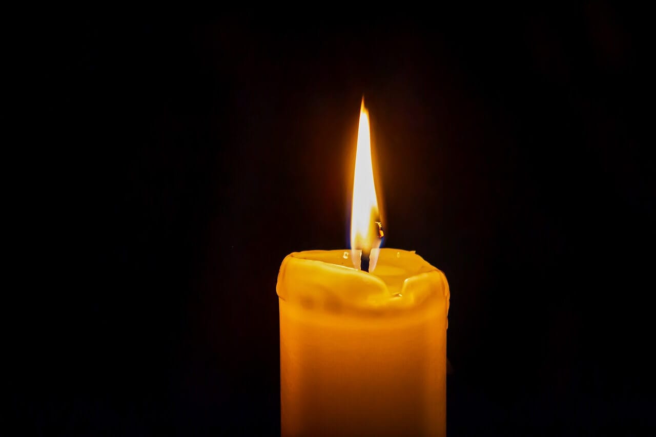 Lighted candle against dark background - Elisa Pixabay